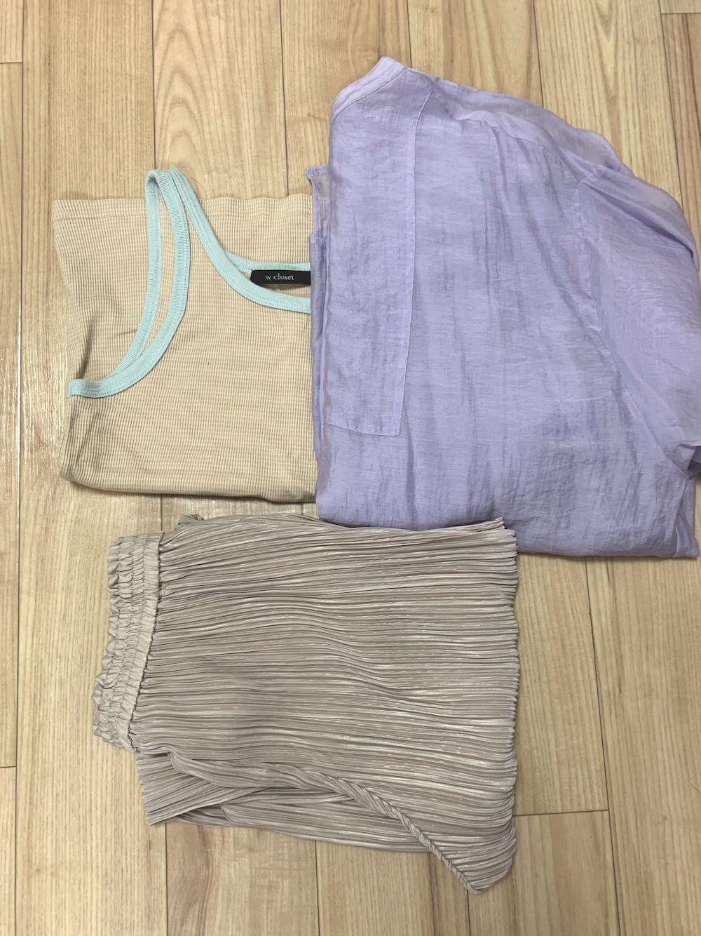 オレンジ系のタンクトップ、パープル系のシャツ/ブラウス、ベージュ系のパンツを着用したレディースの夏コーディネートの1枚目の写真