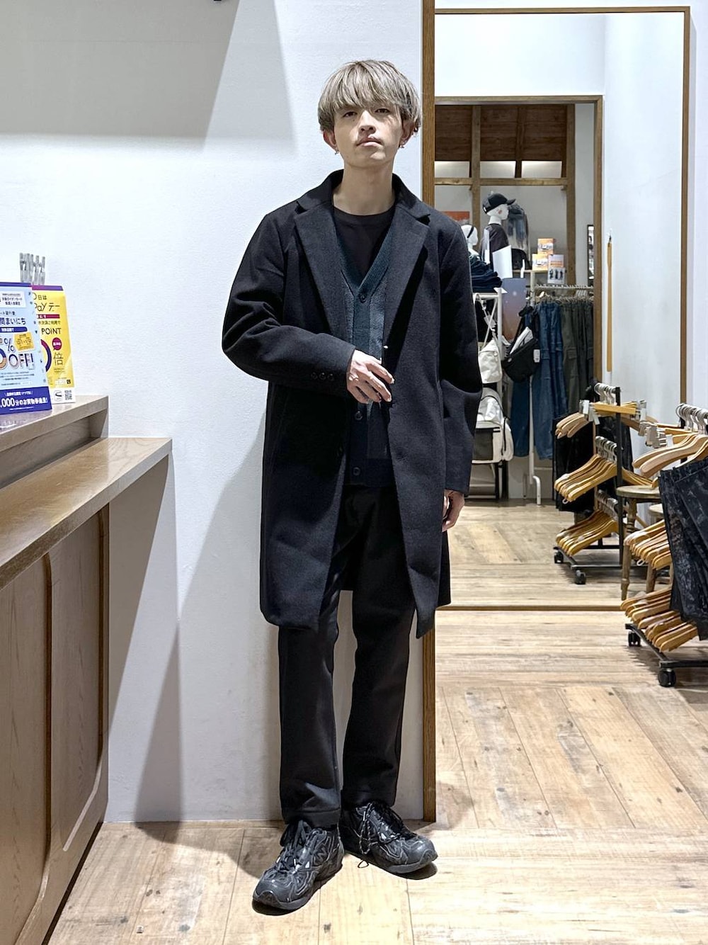 ブラック系のチェスターコート、ブラック系のその他パンツ、グリーン系のカーディガン/ボレロを着用したメンズの冬コーディネートの1枚目の写真