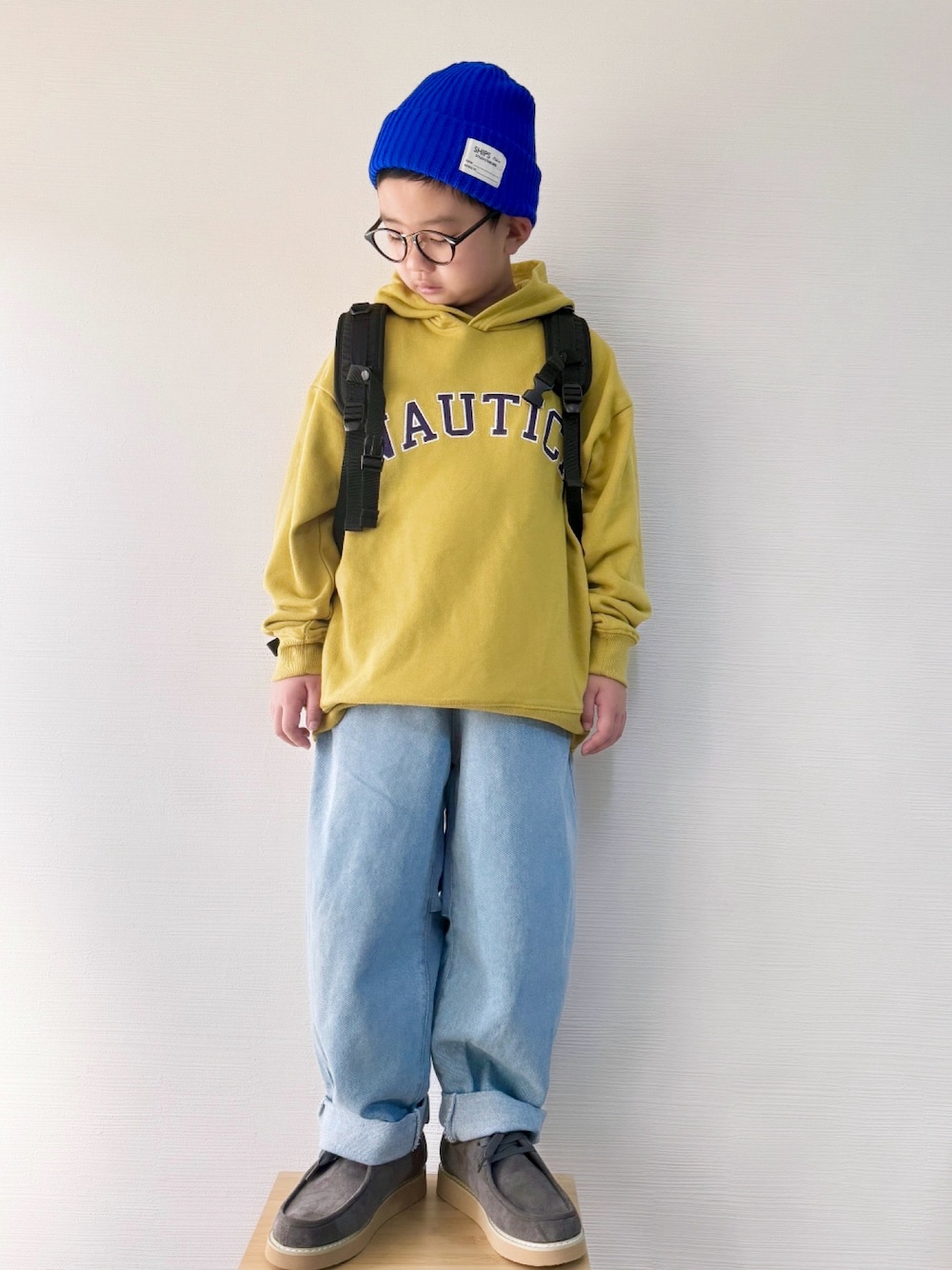 「ストリート、モカシン、マスタード、パーカー、リュック、カジュアル、男の子、ニット帽、小学生、デニム、ワイドパンツ、めがね、キッズコーデ、ショートブーツ、冬コーデ」｜「NAUTICAの【NAUTICA/ノーティカ】アップリケロゴ裏毛パーカー（パーカー、イエロー系）」を使った、yo_yoさん（キッズ・120cm）の冬コーディネートの1枚目の写真