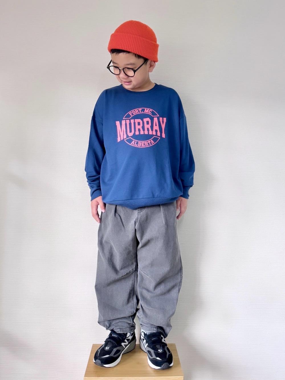 ブルー系のスウェット、ブラック系のデニムパンツ、ブラック系のスニーカーを着用したキッズの秋コーディネートの1枚目の写真