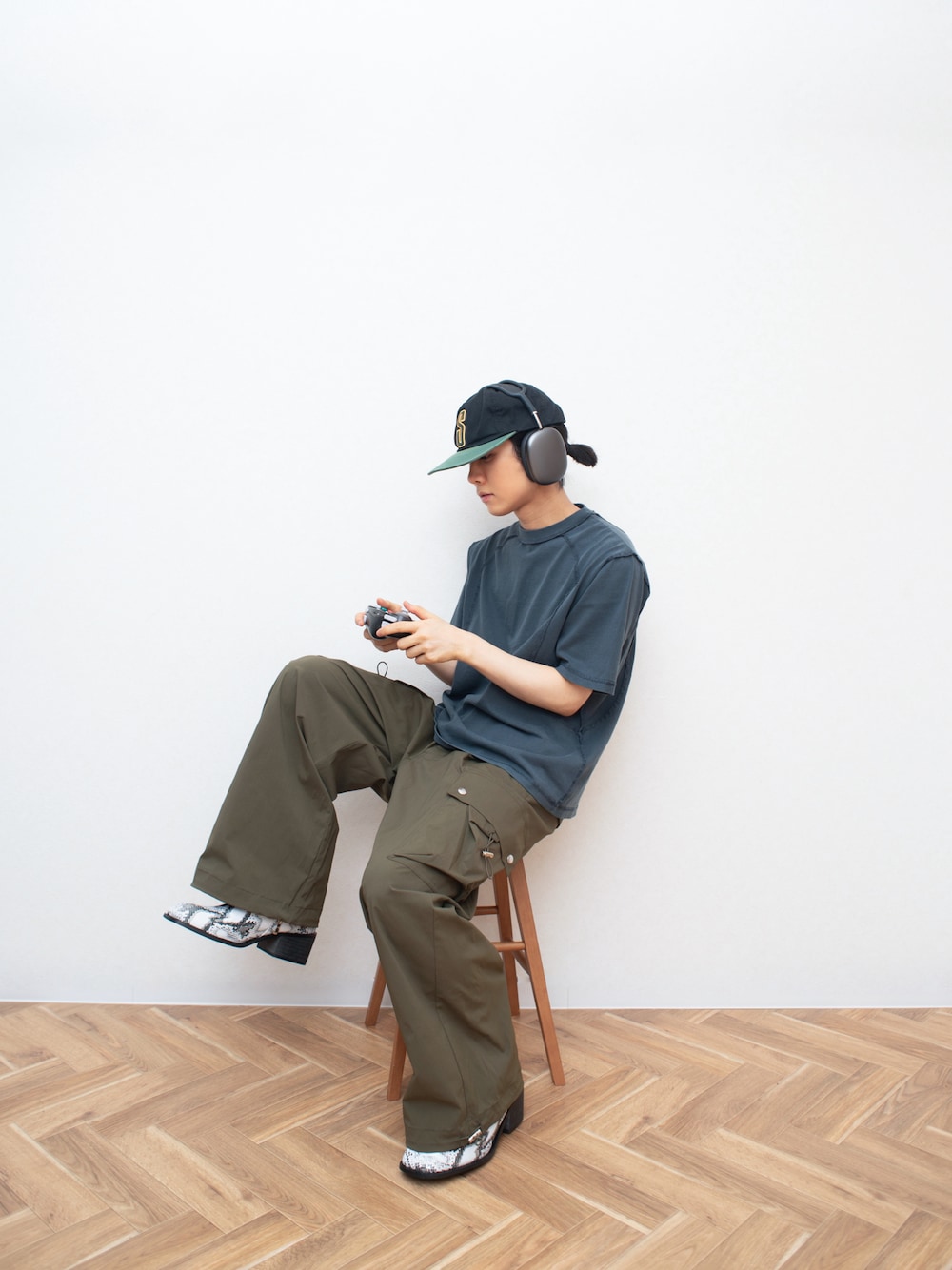 グレー系のTシャツ/カットソー、グリーン系のカーゴパンツ、ホワイト系のブーツを着用したメンズの夏コーディネートの1枚目の写真