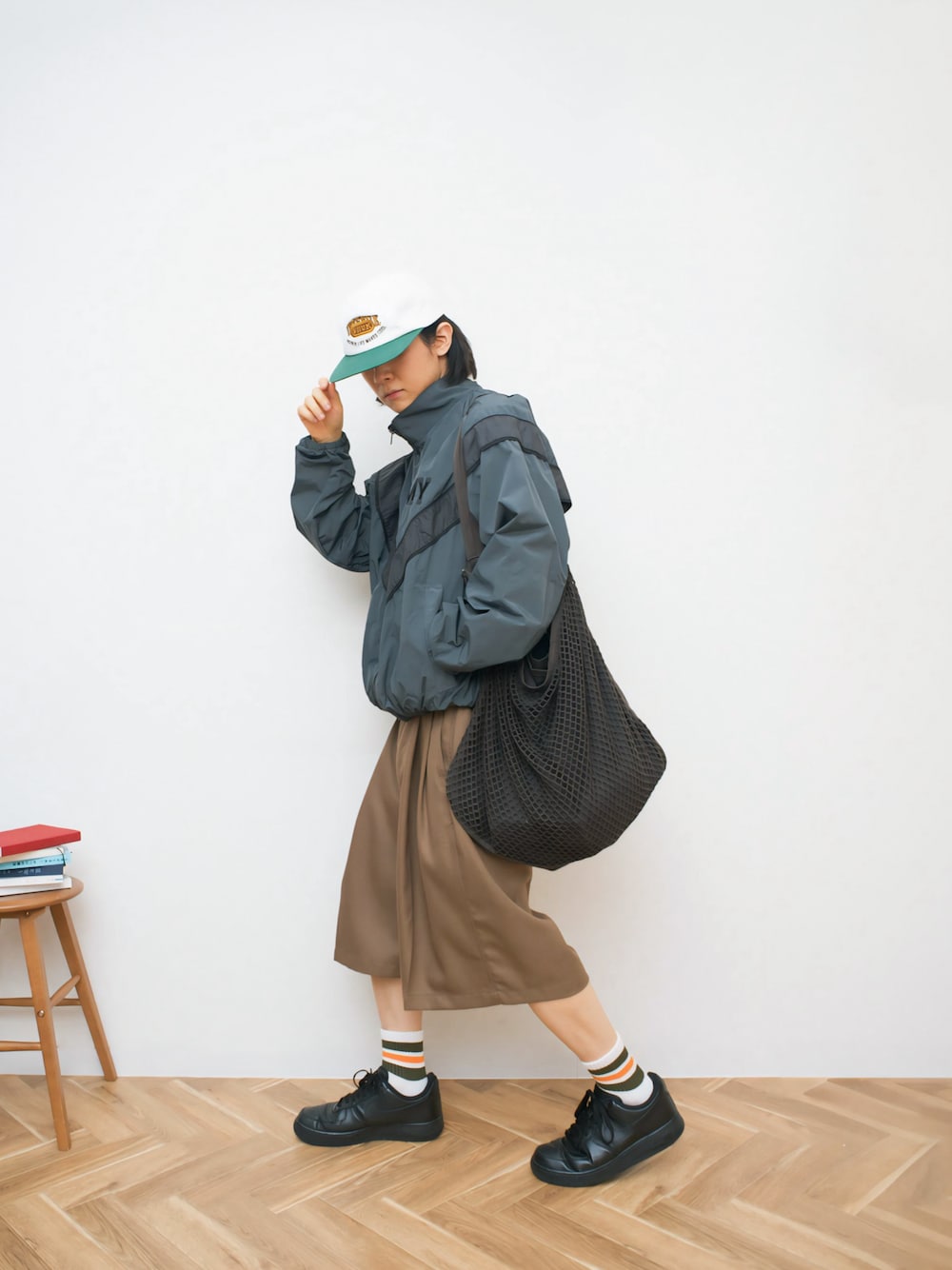 グレー系のナイロンジャケット、ブラック系のショルダーバッグ、ベージュ系のその他パンツを着用したメンズの秋コーディネートの1枚目の写真