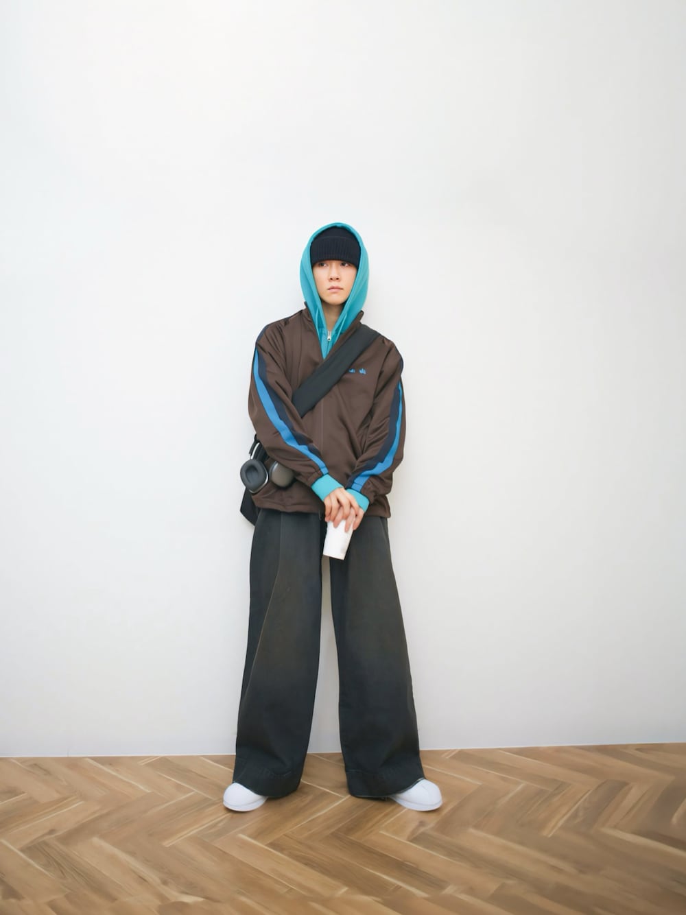 ブラウン系のジャージ、ブルー系のパーカー、ブラック系のデニムパンツを着用したメンズの秋コーディネートの1枚目の写真