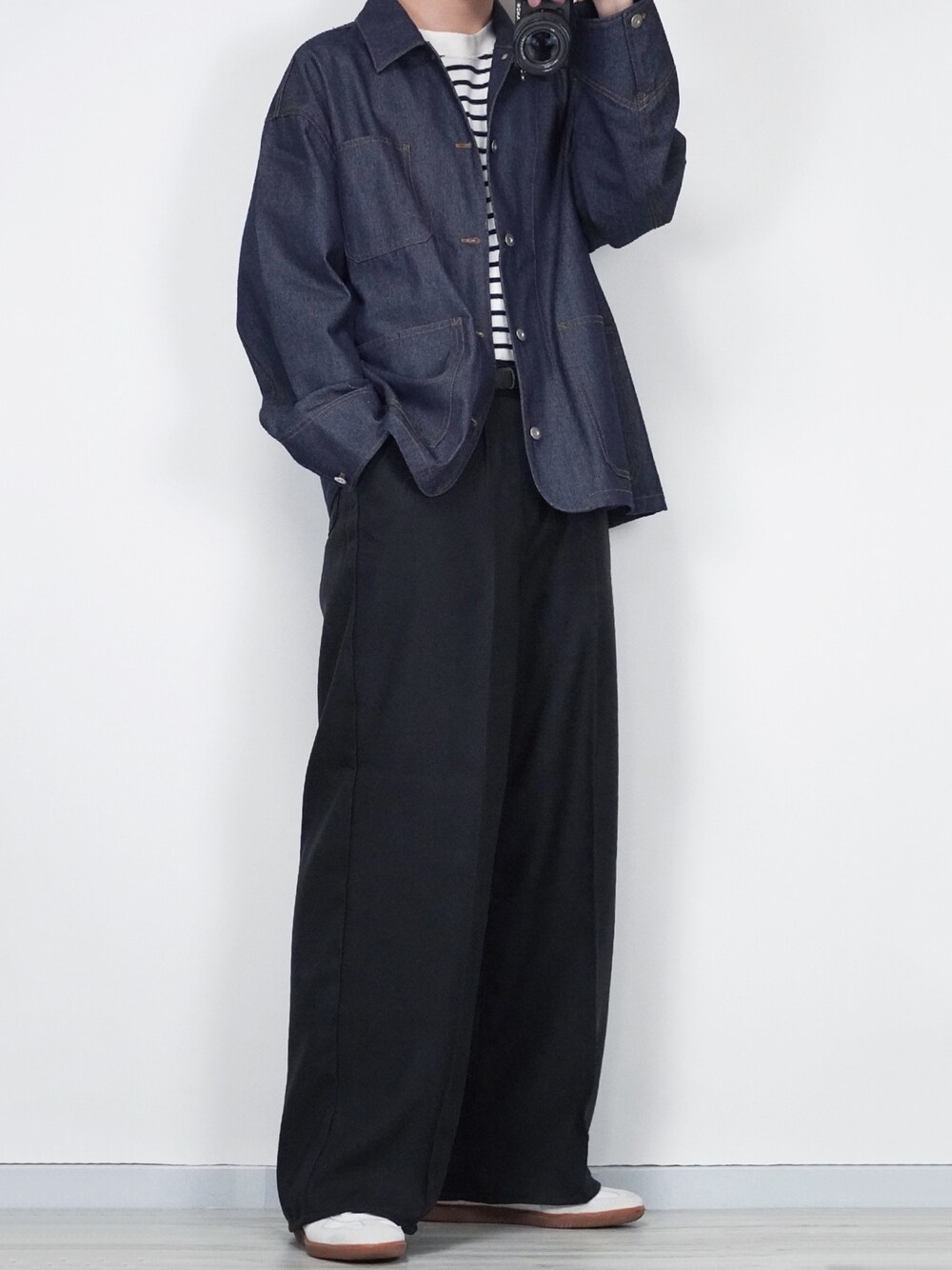 ブルー系のデニムジャケット、ブラック系のスラックス、ホワイト系のスニーカーを着用したメンズの春コーディネートの1枚目の写真