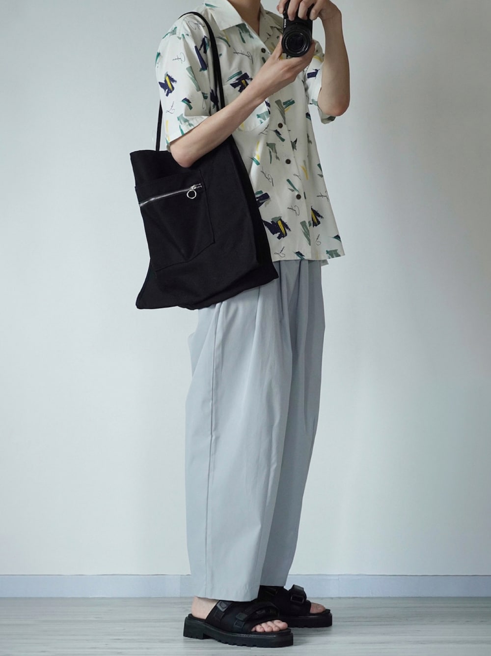 ホワイト系のシャツ/ブラウス、グレー系のその他パンツ、ブラック系のサンダルを着用したメンズの夏コーディネートの1枚目の写真