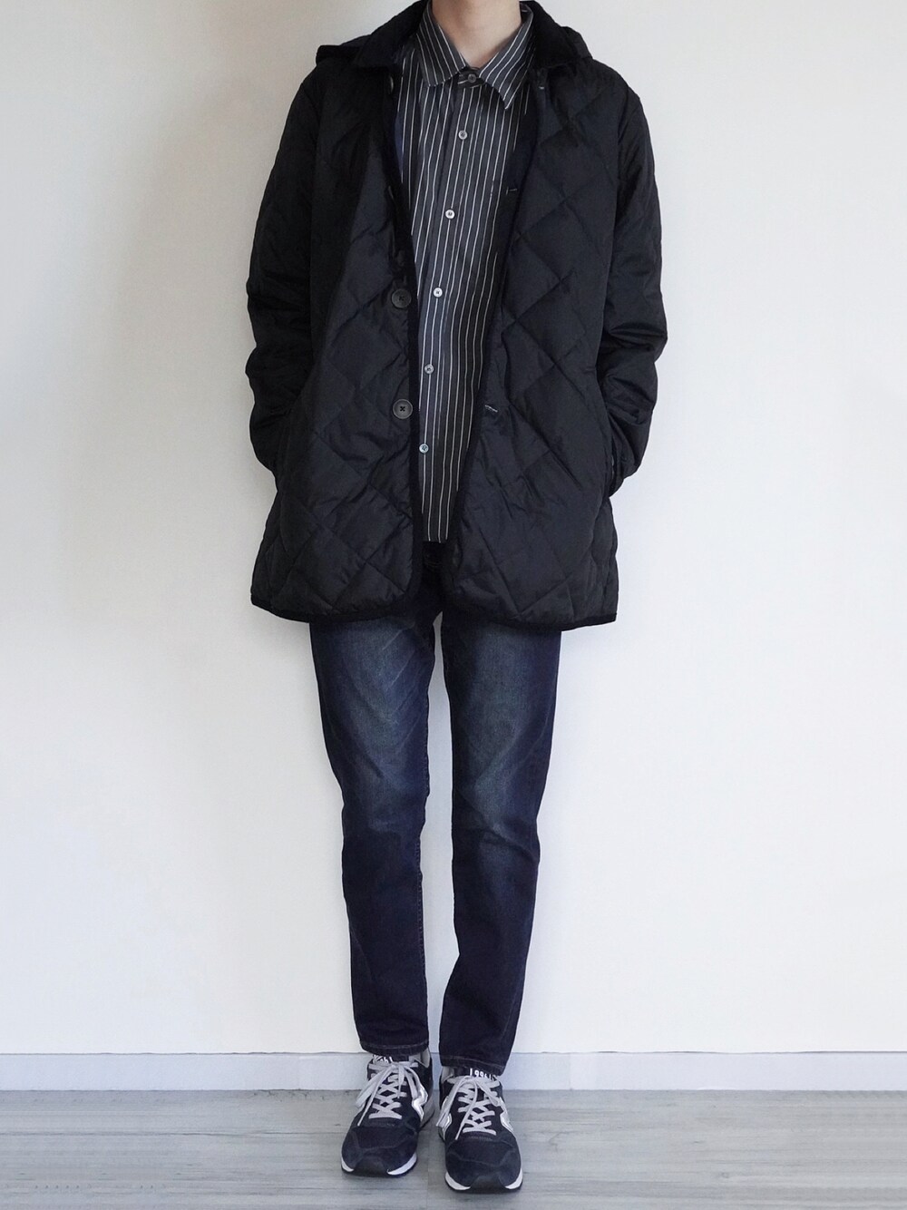 ブラック系のダウンジャケット/コート、ブラック系のTシャツ/カットソー、ブルー系のデニムパンツを着用したメンズの冬コーディネートの1枚目の写真