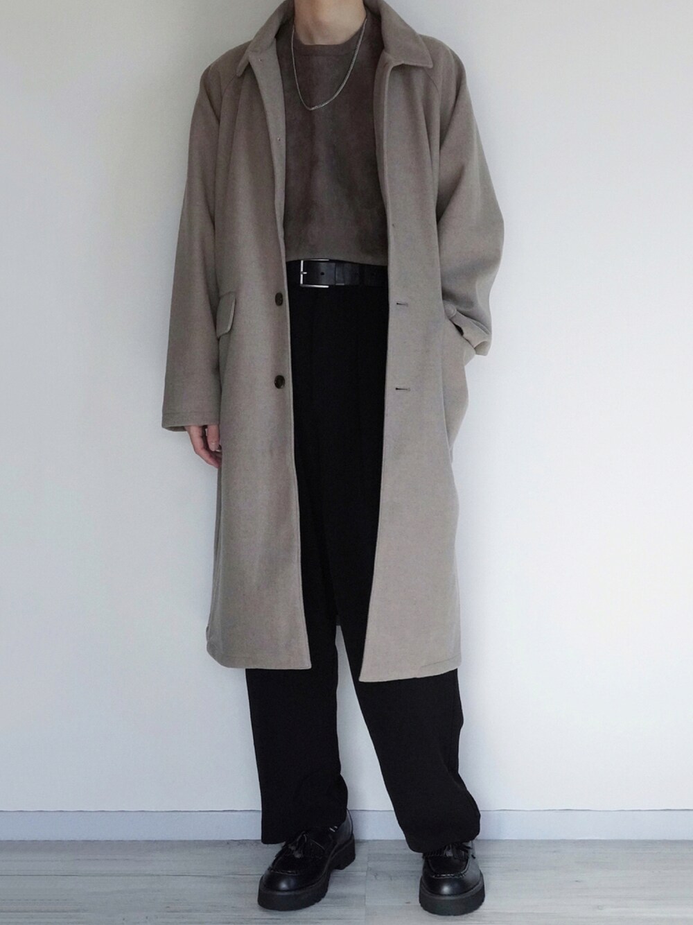 ベージュ系のチェスターコート、グレー系のTシャツ/カットソー、ブラック系のその他パンツを着用したメンズの秋コーディネートの1枚目の写真