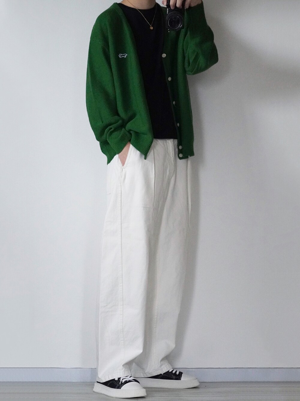 グリーン系のカーディガン/ボレロ、ブラック系のTシャツ/カットソー、ホワイト系のデニムパンツを着用したメンズの秋コーディネートの1枚目の写真