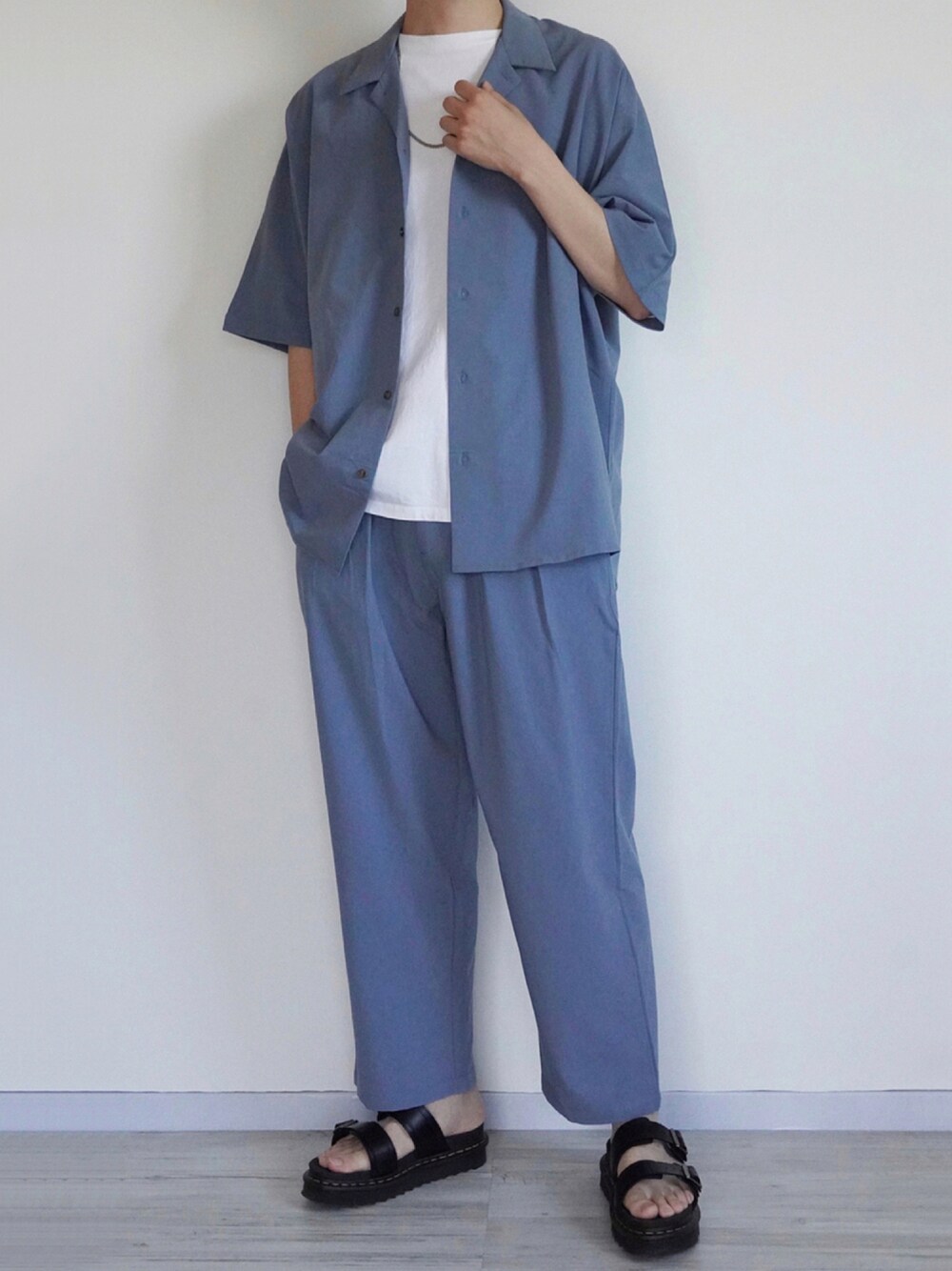ブルー系のセットアップ、ホワイト系のTシャツ/カットソー、ブラック系のサンダルを着用したメンズの夏コーディネートの1枚目の写真