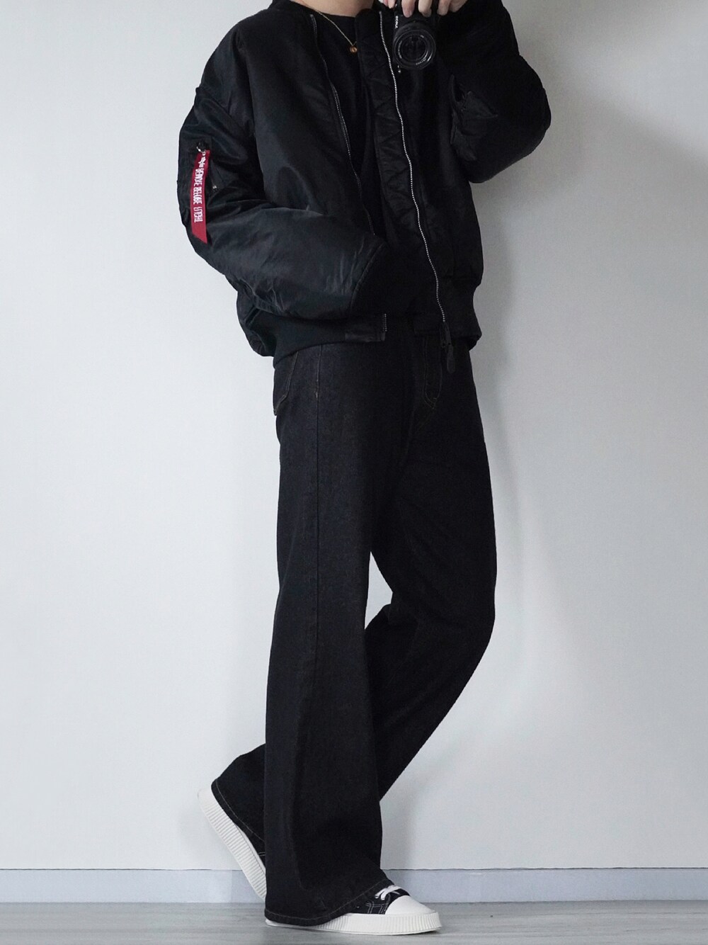 ブラック系のMA-1、ブラック系のデニムパンツ、ブラック系のスニーカーを着用したメンズの秋コーディネートの1枚目の写真
