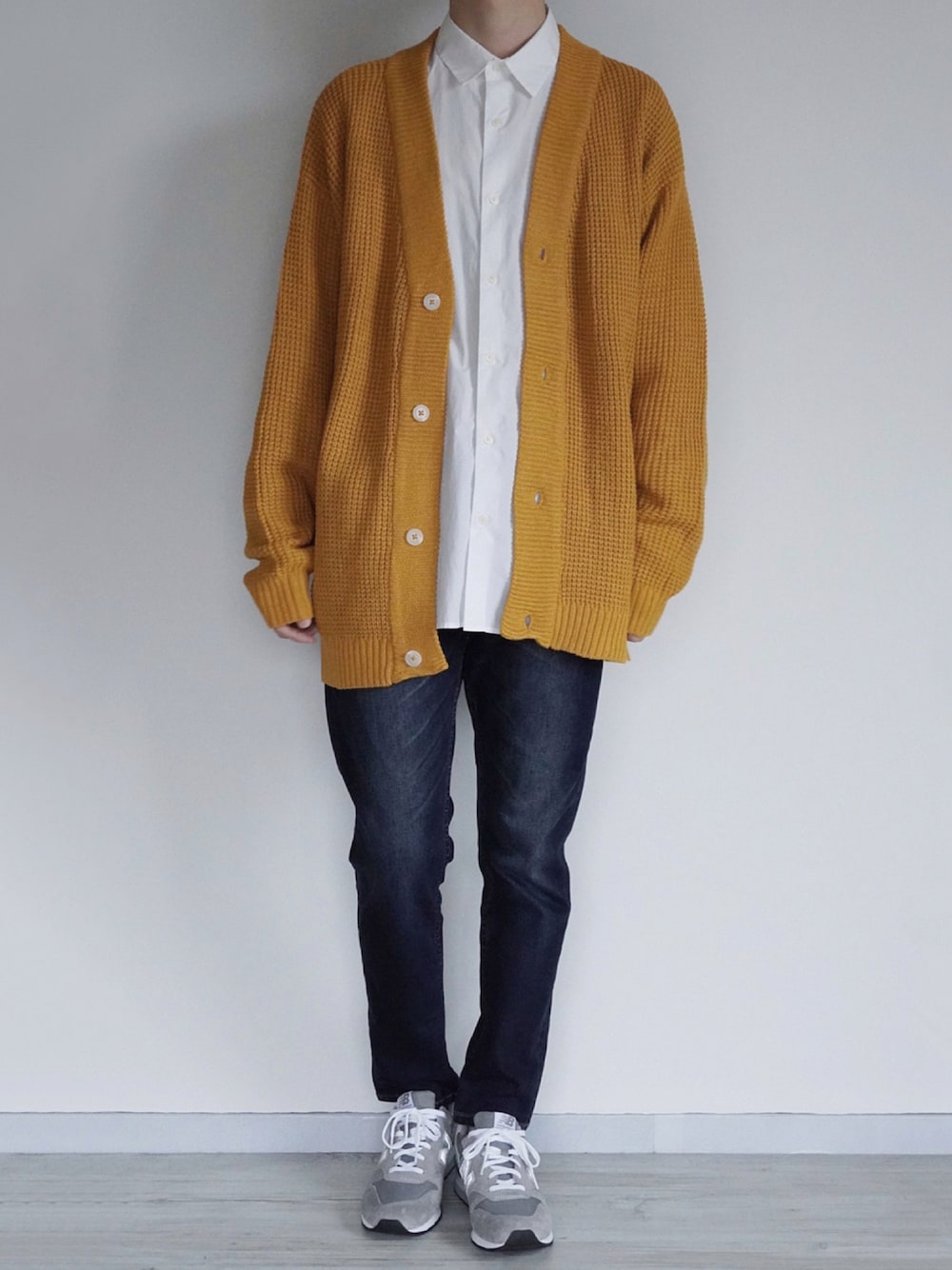 イエロー系のカーディガン/ボレロ、ホワイト系のシャツ/ブラウス、ブルー系のデニムパンツを着用したメンズの秋コーディネートの1枚目の写真