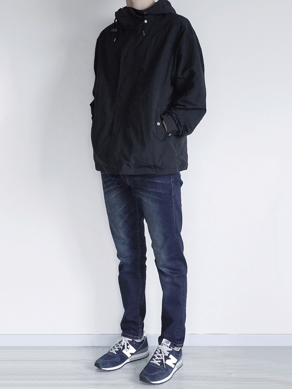ブラック系のマウンテンパーカー、ブラック系のTシャツ/カットソー、ブルー系のデニムパンツを着用したメンズの秋コーディネートの1枚目の写真