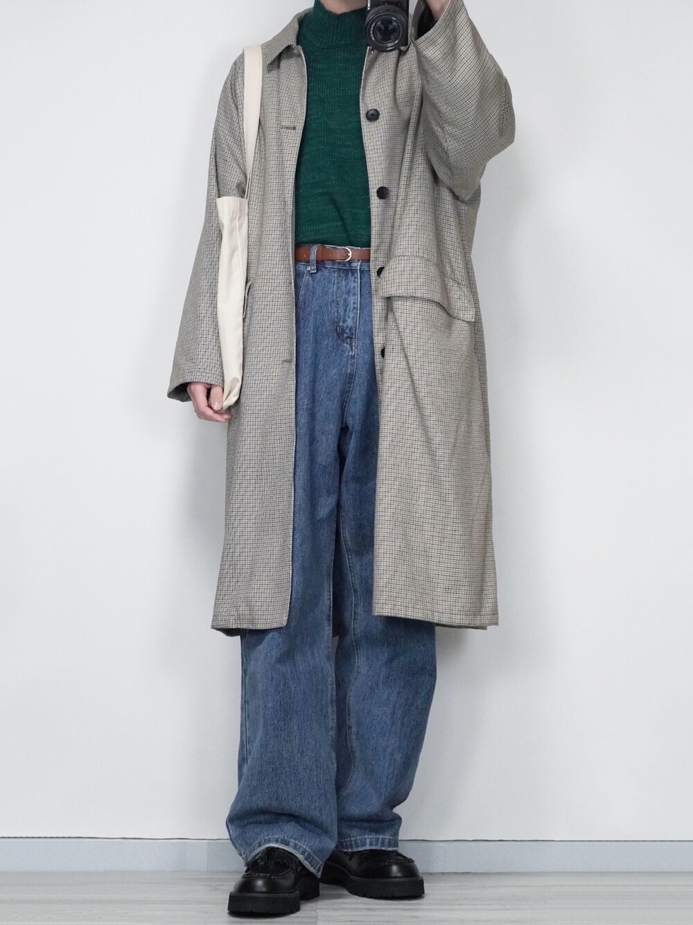 グリーン系のニット/セーター、ブルー系のデニムパンツ、ブラック系のローファーを着用したメンズの冬コーディネートの1枚目の写真