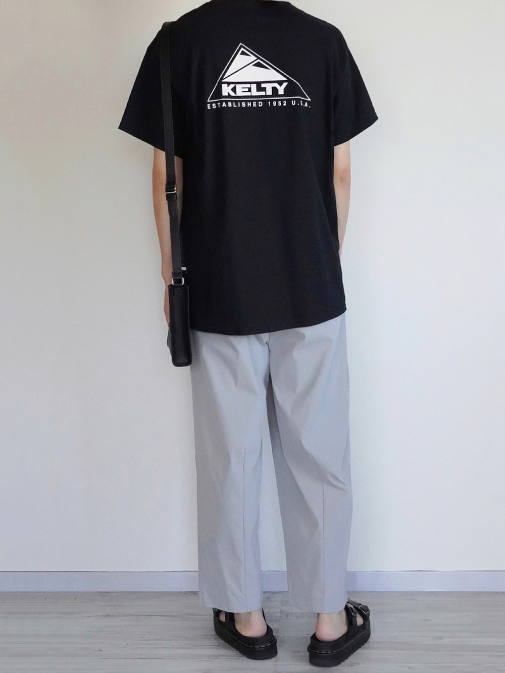 ブラック系のTシャツ/カットソー、グレー系のその他パンツ、ブラック系のサンダルを着用したメンズの夏コーディネートの1枚目の写真