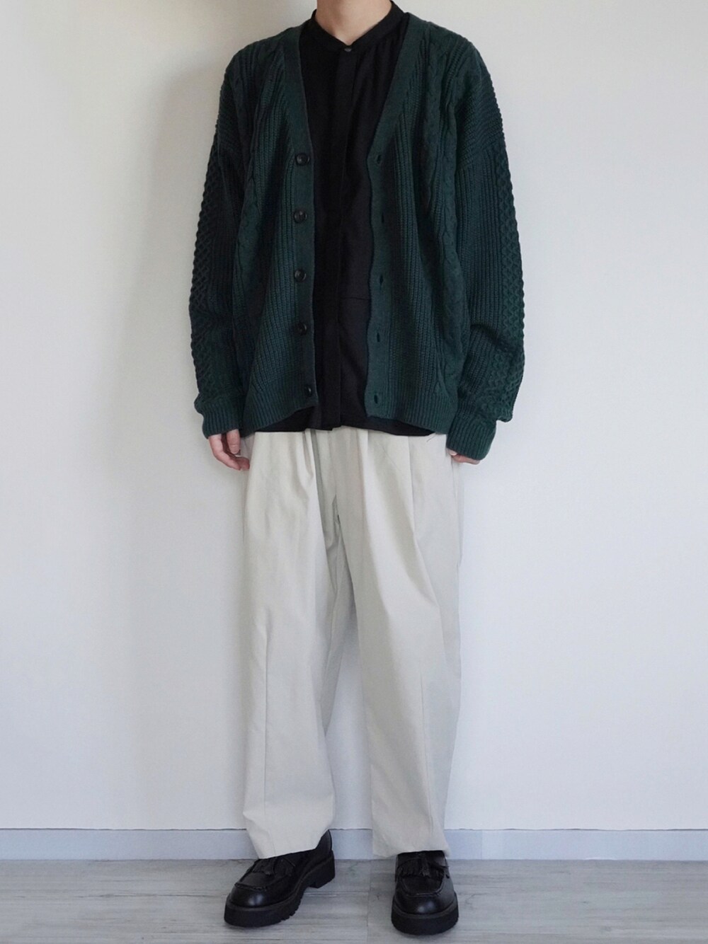 グリーン系のカーディガン/ボレロ、ブラック系のシャツ/ブラウス、ホワイト系のその他パンツを着用したメンズの秋コーディネートの1枚目の写真