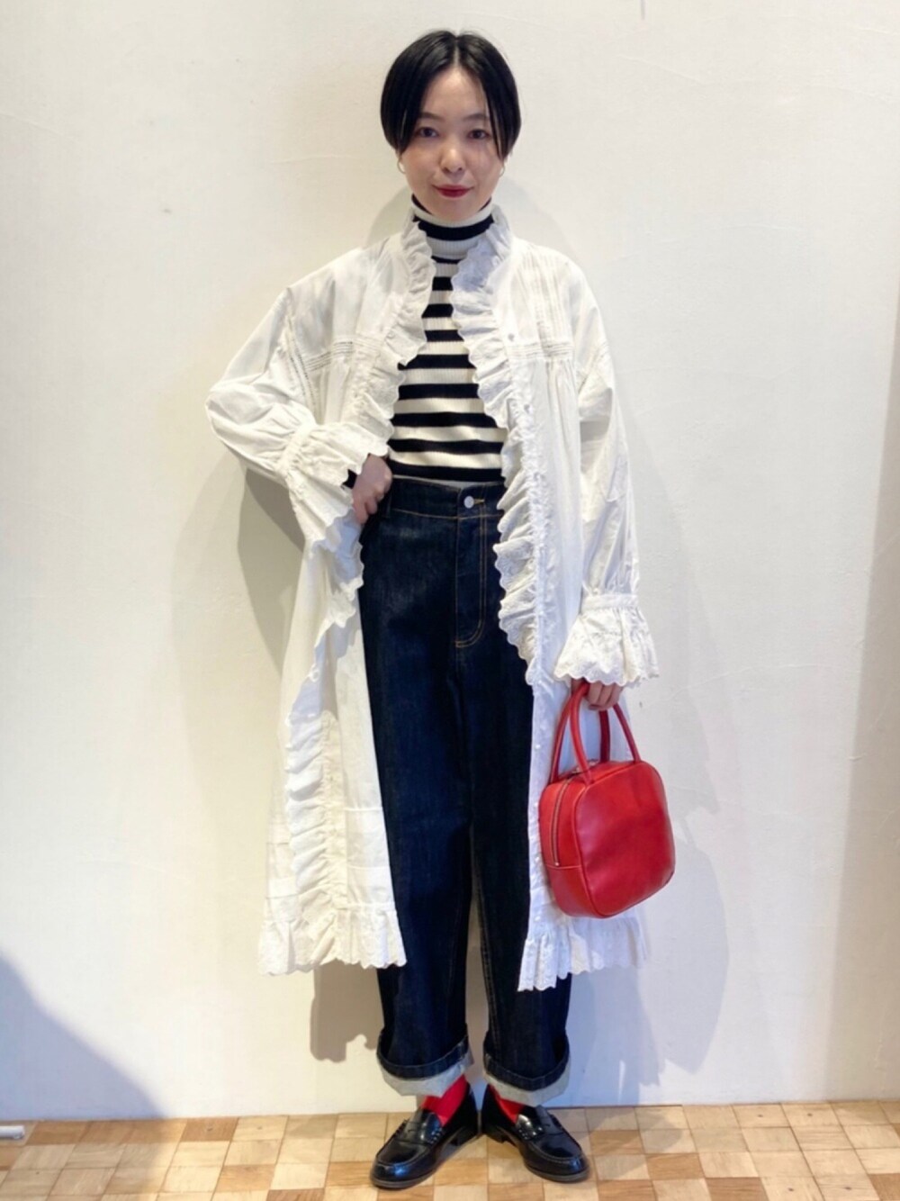 ブルー系のデニムパンツ、ホワイト系のワンピース、その他のニット/セーターを着用したレディースの秋コーディネートの1枚目の写真