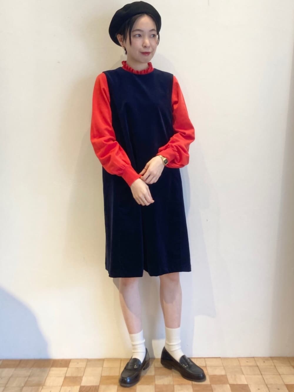 オレンジ系のニット/セーター、ブルー系のワンピースを着用したレディースの秋コーディネートの1枚目の写真