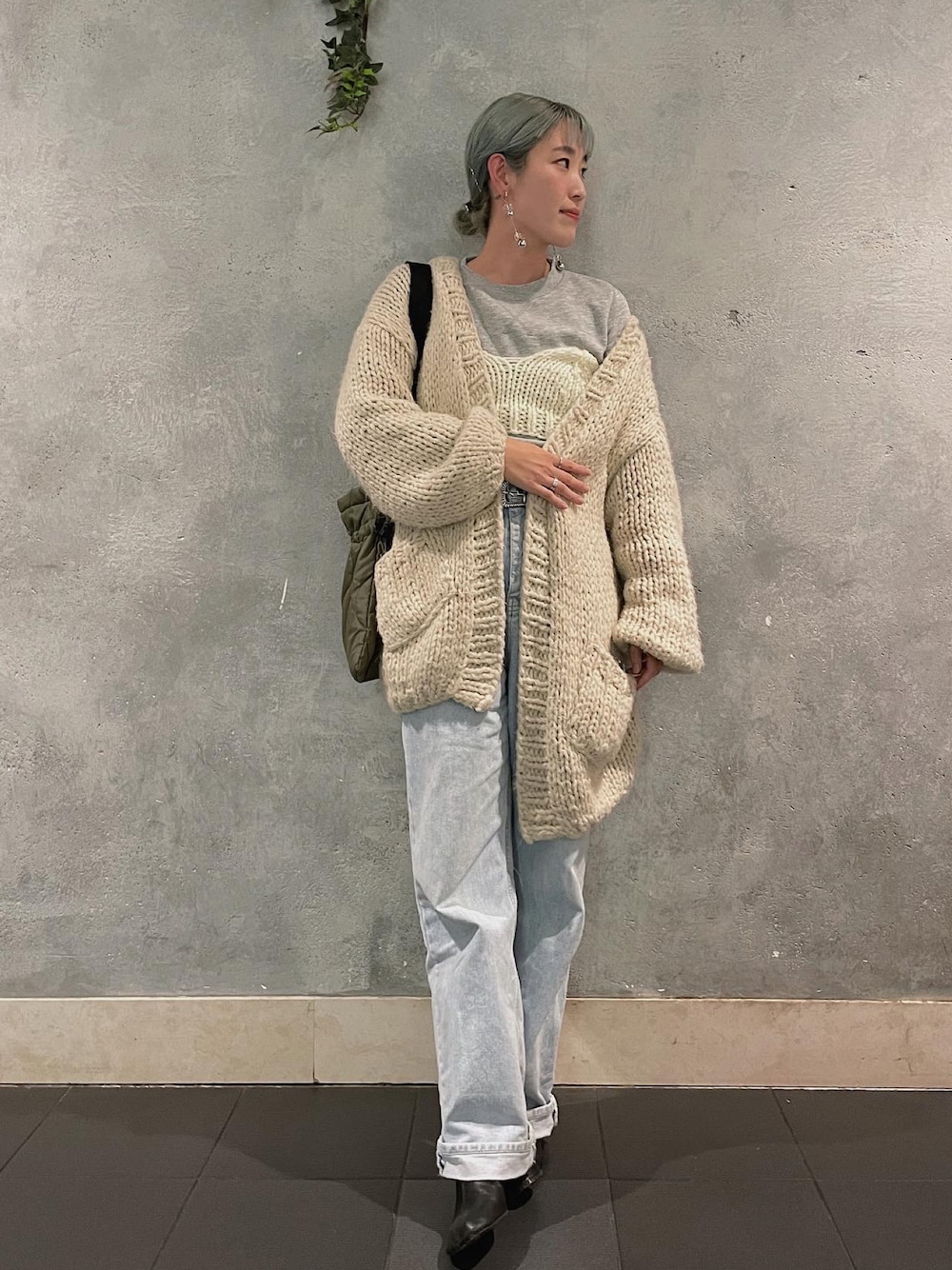 ベージュ系のカーディガン/ボレロ、ブルー系のデニムパンツ、ベージュ系のニット/セーターを着用したレディースの秋コーディネートの1枚目の写真