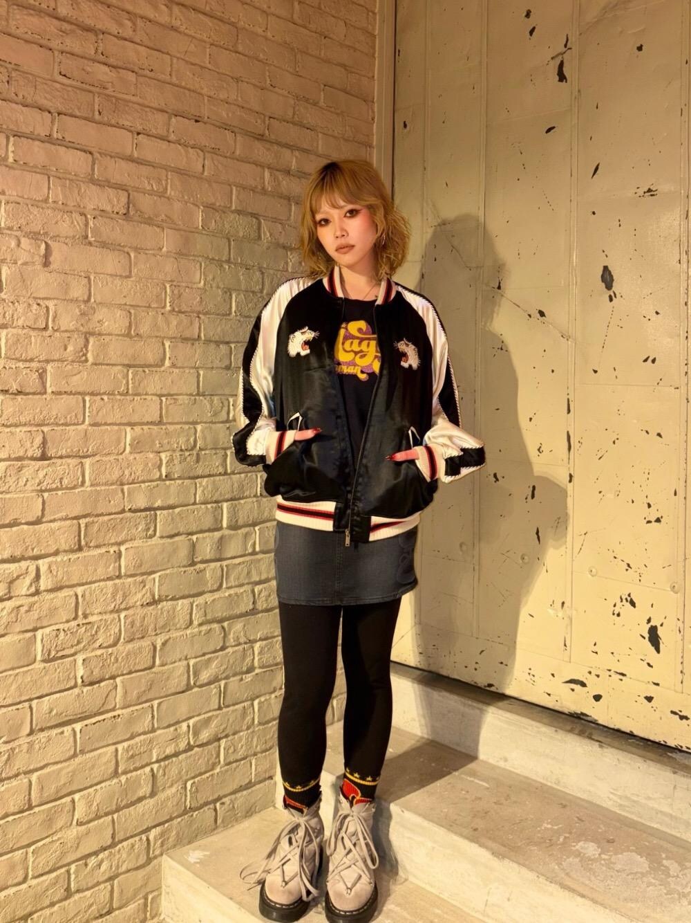 ブラック系のデニムスカート、ブラック系のブルゾン、ブラック系のTシャツ/カットソーを着用したレディースの冬コーディネートの1枚目の写真