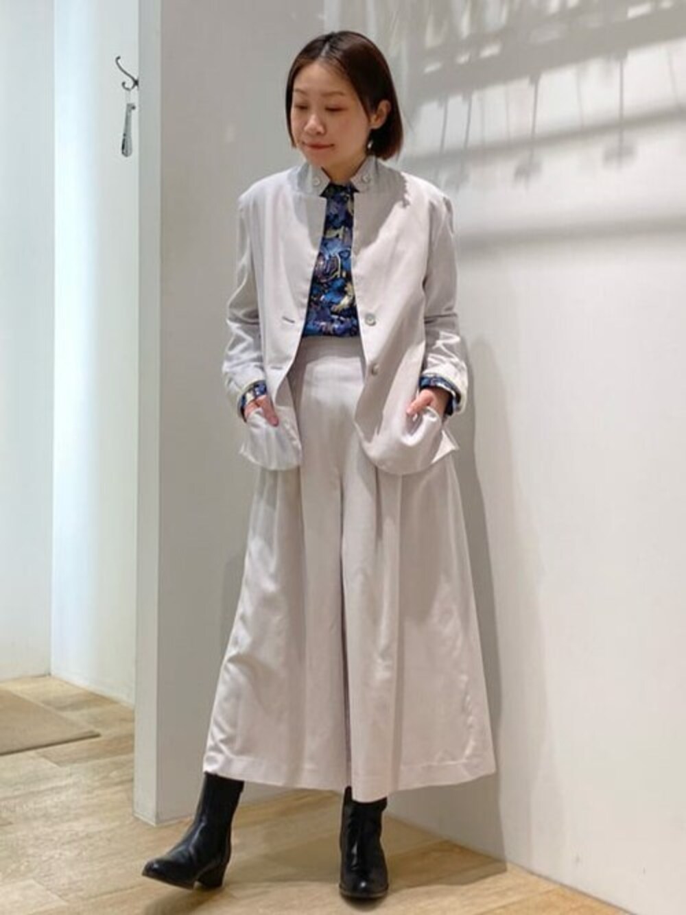 グレー系のテーラードジャケット、ブルー系のシャツ/ブラウス、グレー系のスカートを着用したレディースの春コーディネートの1枚目の写真