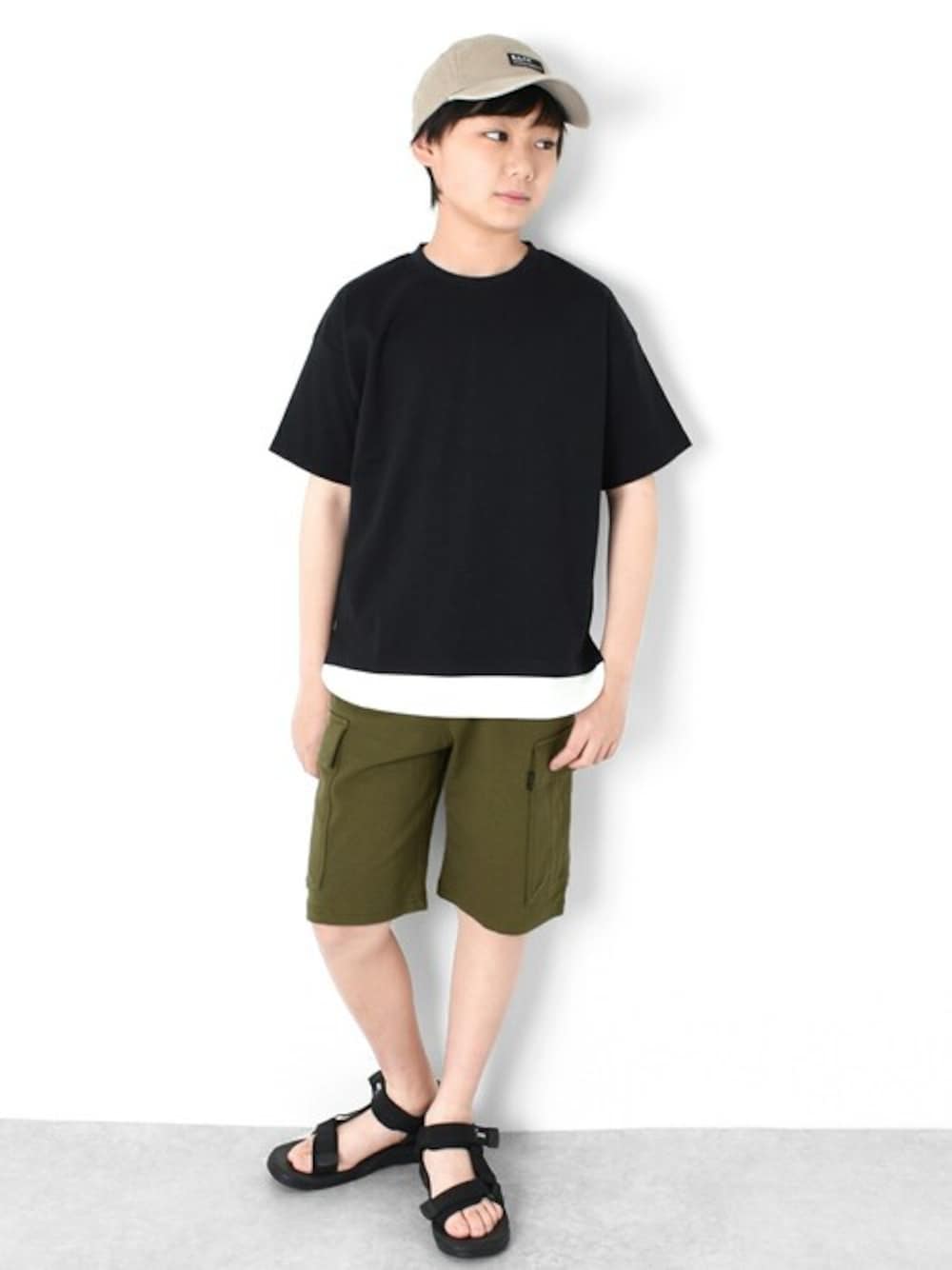 グリーン系のカーゴパンツ、ブラック系のTシャツ/カットソー、ベージュ系のキャップを着用したキッズの春コーディネートの1枚目の写真