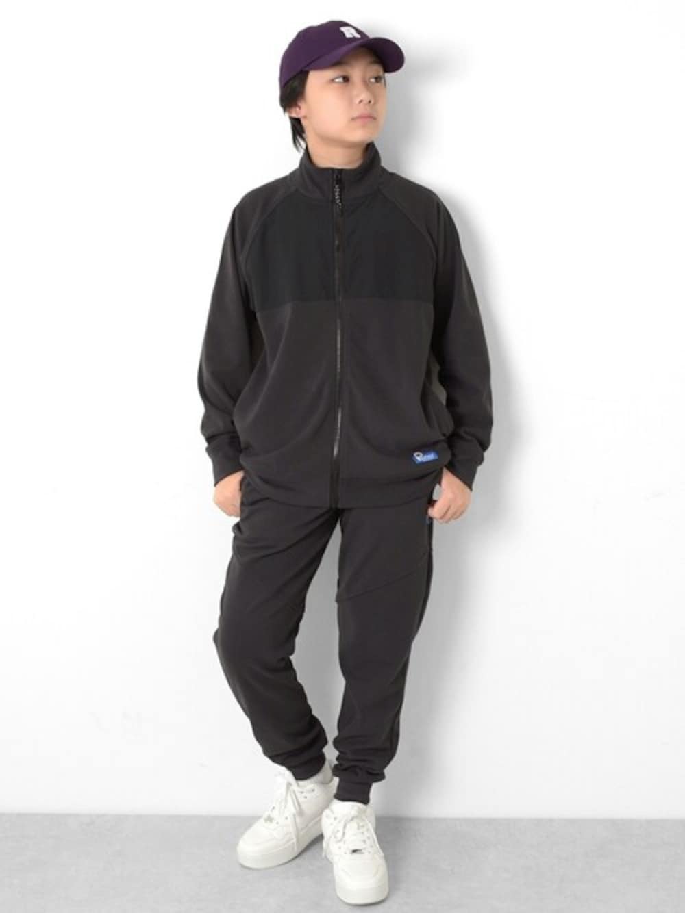 グレー系のブルゾン、グレー系のその他パンツ、パープル系のキャップを着用したキッズの冬コーディネートの1枚目の写真