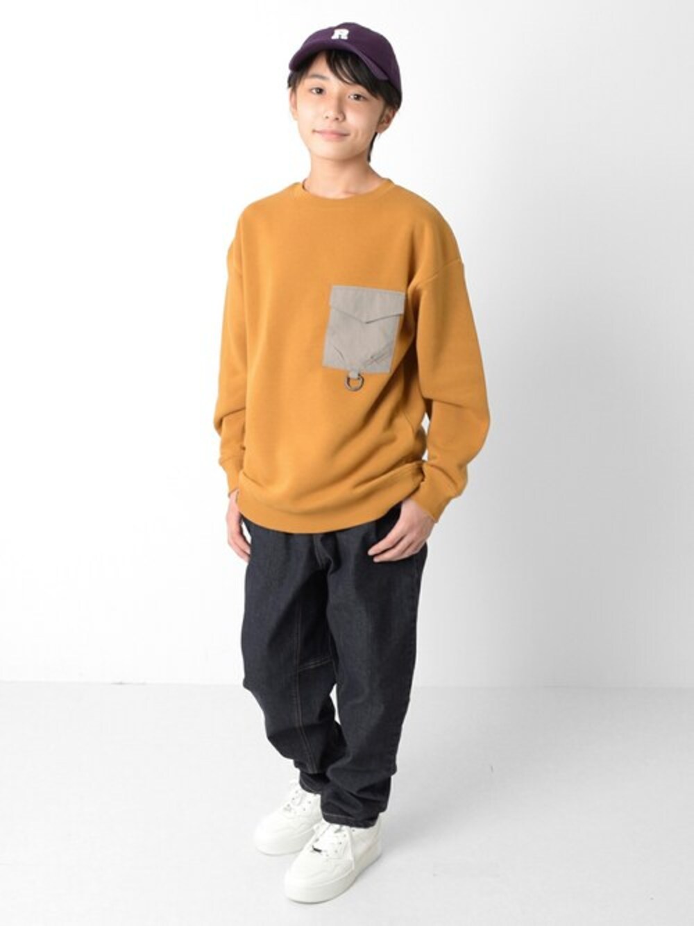 ベージュ系のスウェット、ブルー系のその他パンツ、パープル系のキャップを着用したキッズの冬コーディネートの1枚目の写真