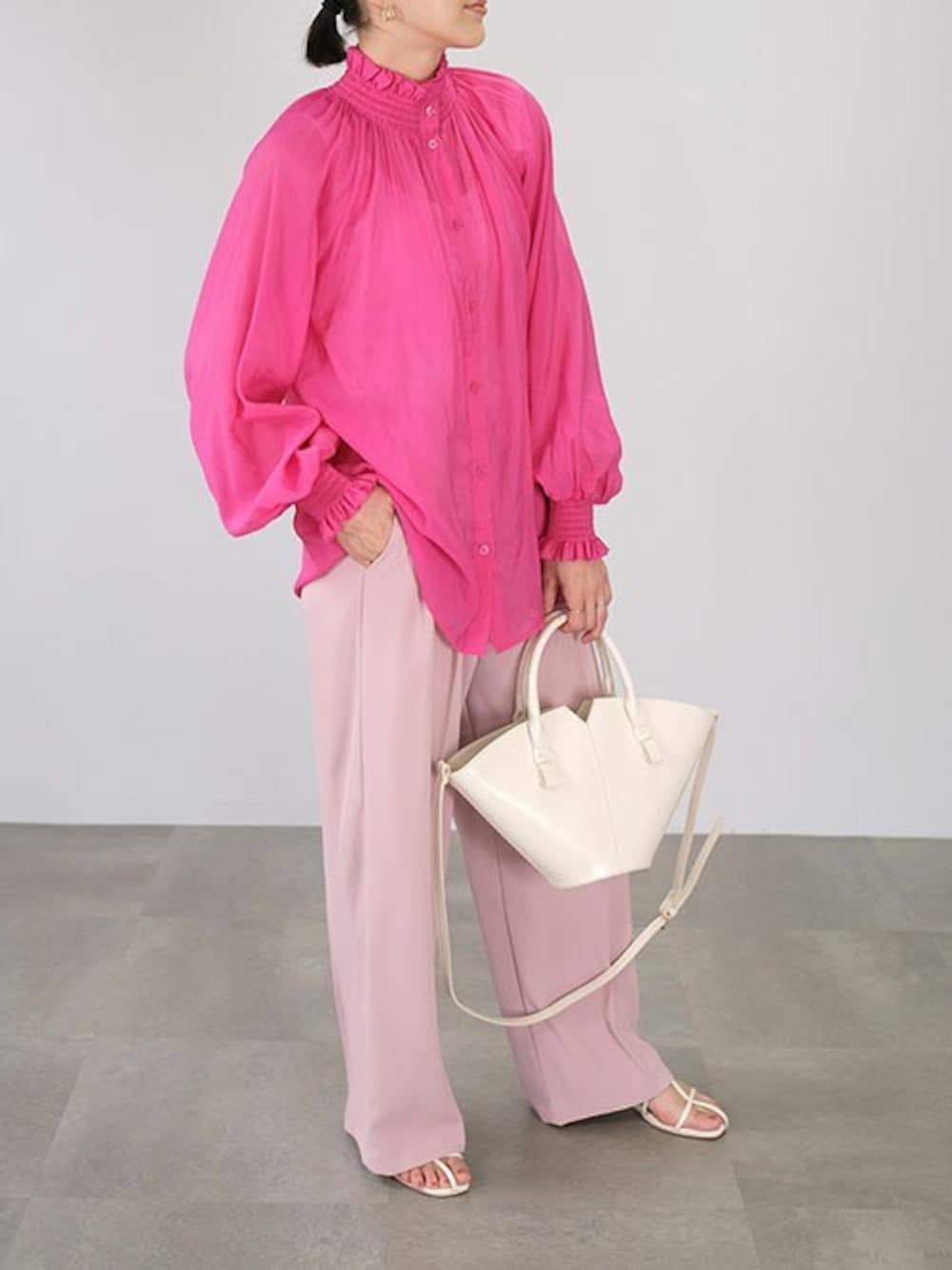 ピンク系のシャツ/ブラウス、ピンク系のスラックスを着用したレディースの春コーディネートの1枚目の写真