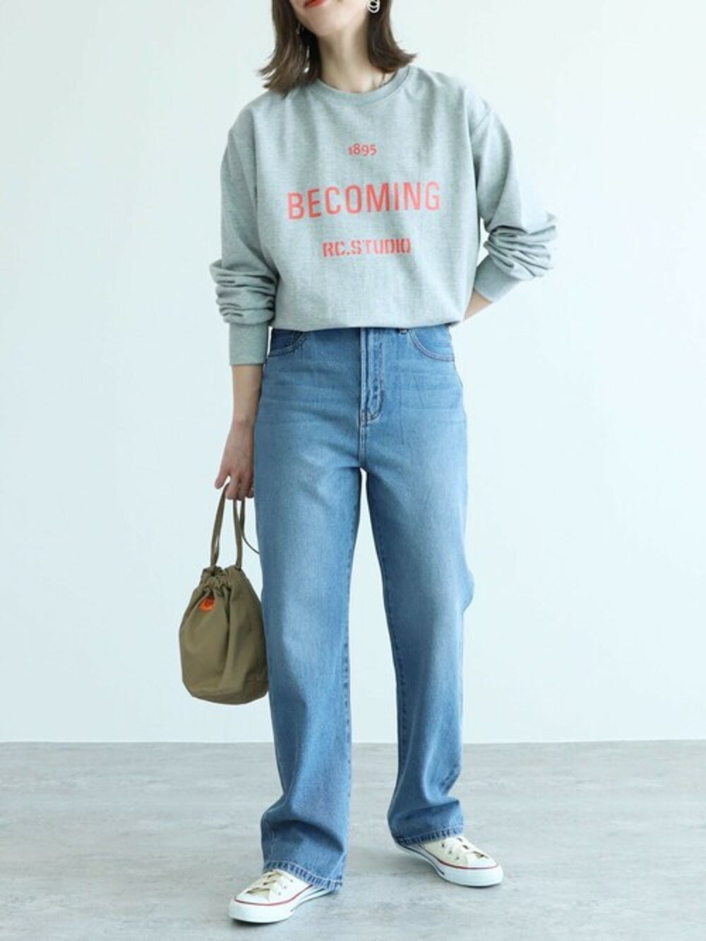 ブルー系のデニムパンツ、グレー系のTシャツ/カットソーを着用したレディースの春コーディネートの1枚目の写真
