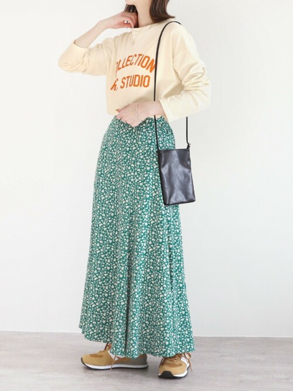 ホワイト系のTシャツ/カットソー、グリーン系のスカートを着用したレディースの春コーディネートの1枚目の写真