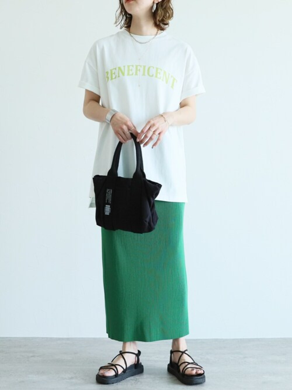 グリーン系のスカート、ホワイト系のTシャツ/カットソーを着用したレディースの春コーディネートの1枚目の写真