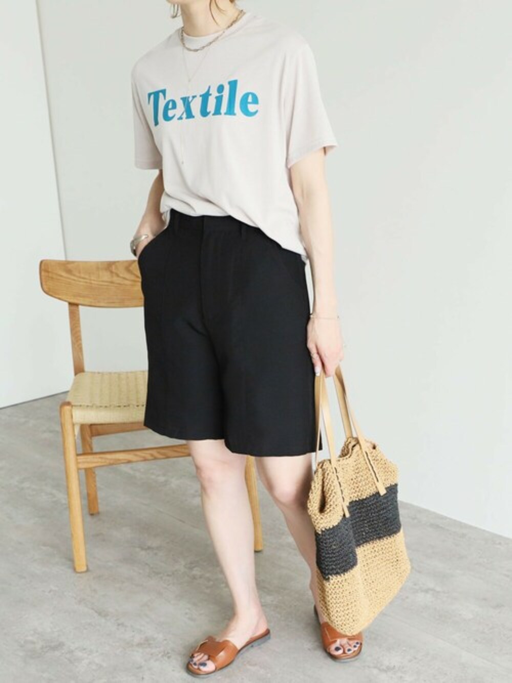 ブラック系のその他パンツ、ベージュ系のTシャツ/カットソーを着用したレディースの春コーディネートの1枚目の写真