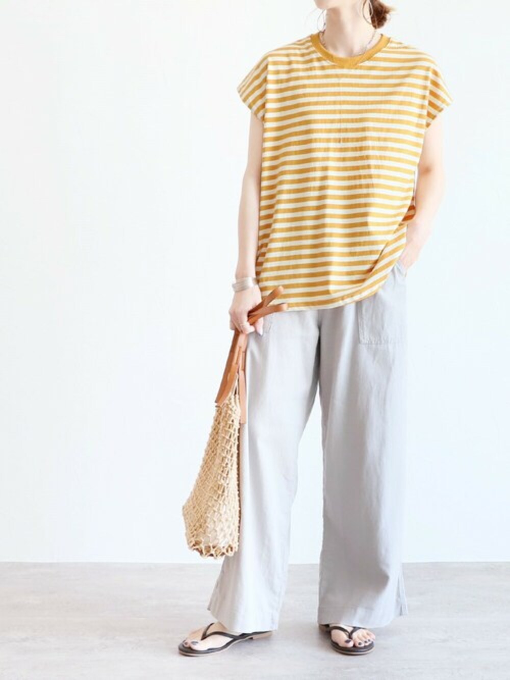 イエロー系のTシャツ/カットソー、グレー系のその他パンツを着用したレディースの夏コーディネートの1枚目の写真