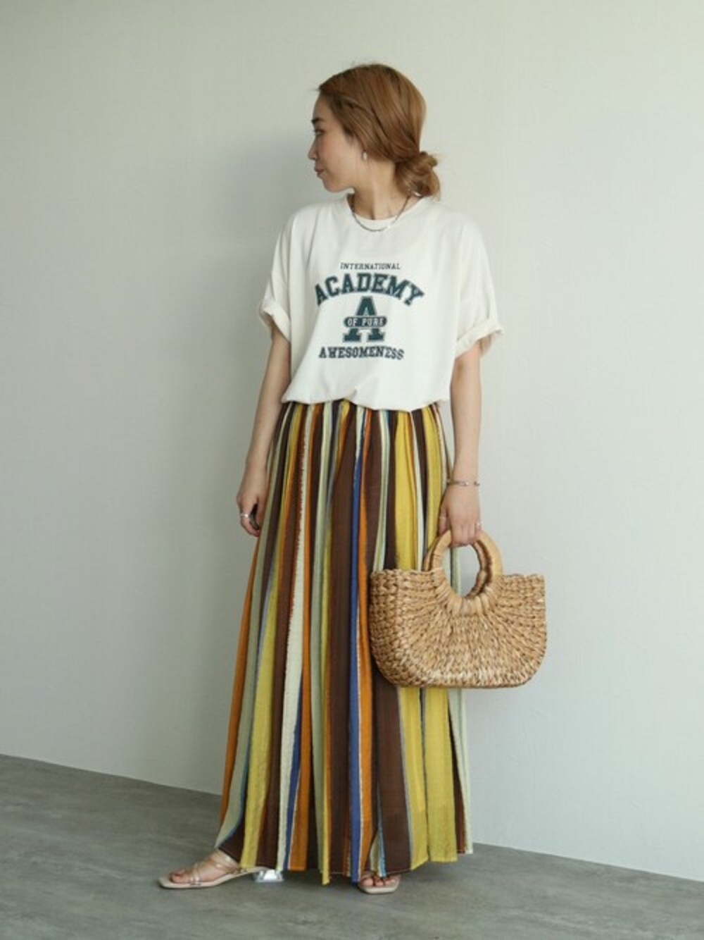 ベージュ系のTシャツ/カットソー、オレンジ系のスカートを着用したレディースの夏コーディネートの1枚目の写真