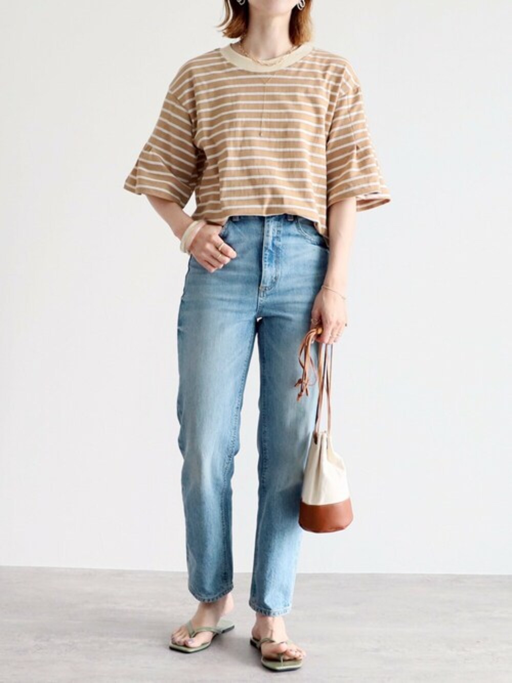 ベージュ系のTシャツ/カットソーを着用したレディースの夏コーディネートの1枚目の写真