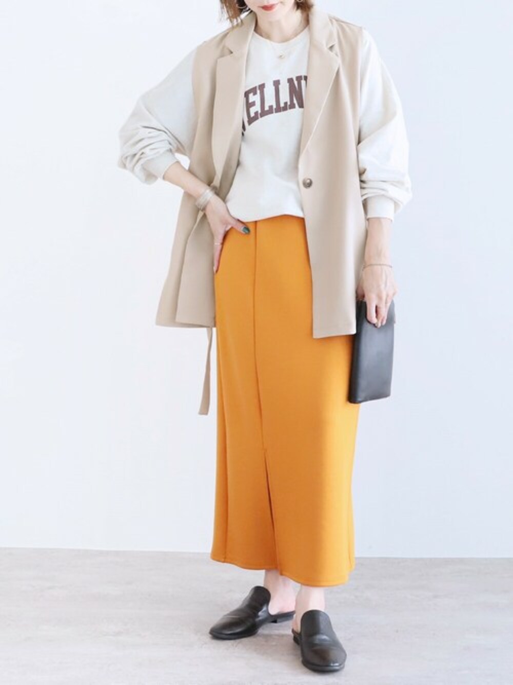 ベージュ系のベスト、イエロー系のスカートを着用したレディースの夏コーディネートの1枚目の写真