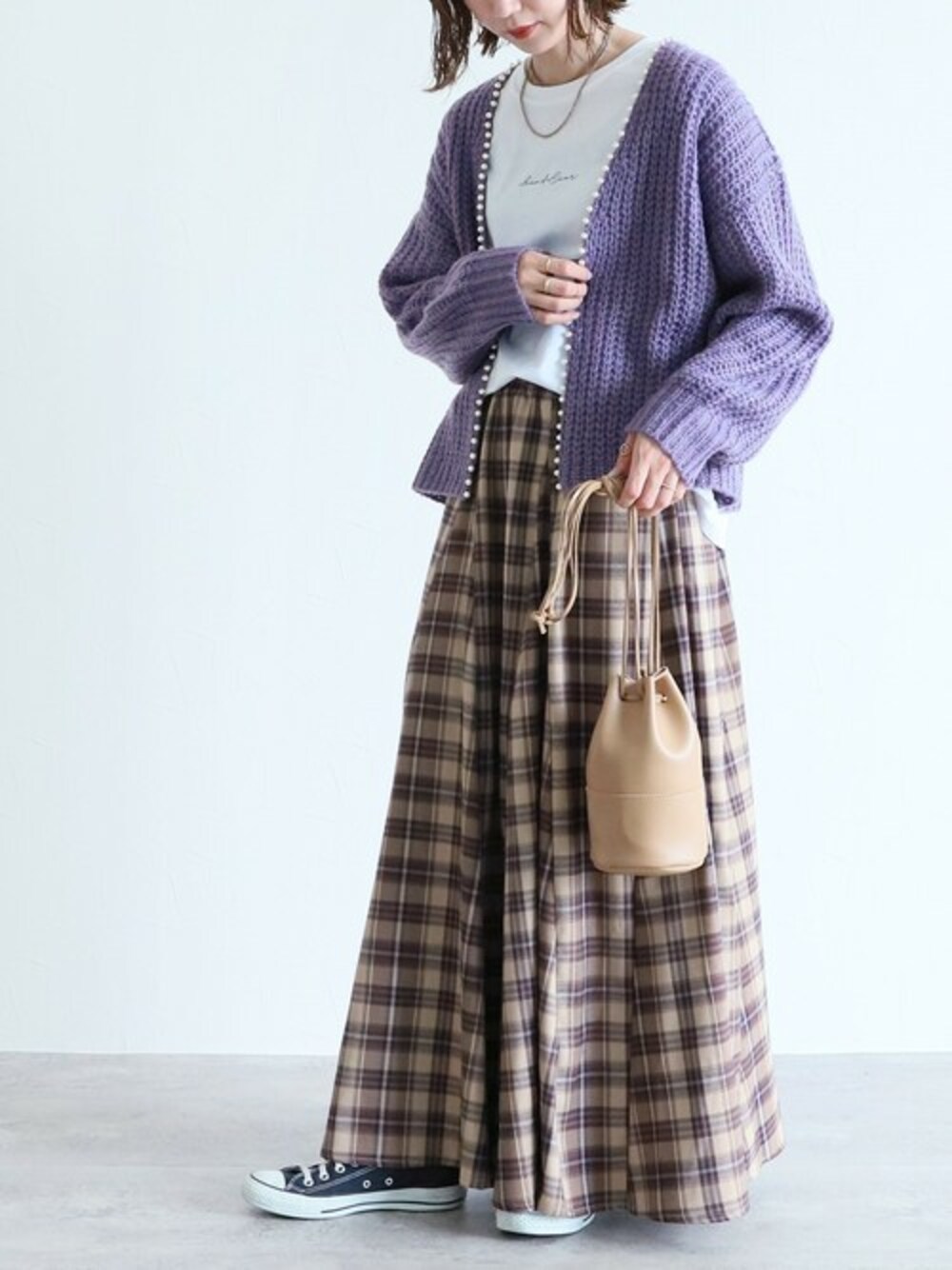 ベージュ系のスカート、ホワイト系のTシャツ/カットソー、パープル系のカーディガン/ボレロを着用したレディースの秋コーディネートの1枚目の写真