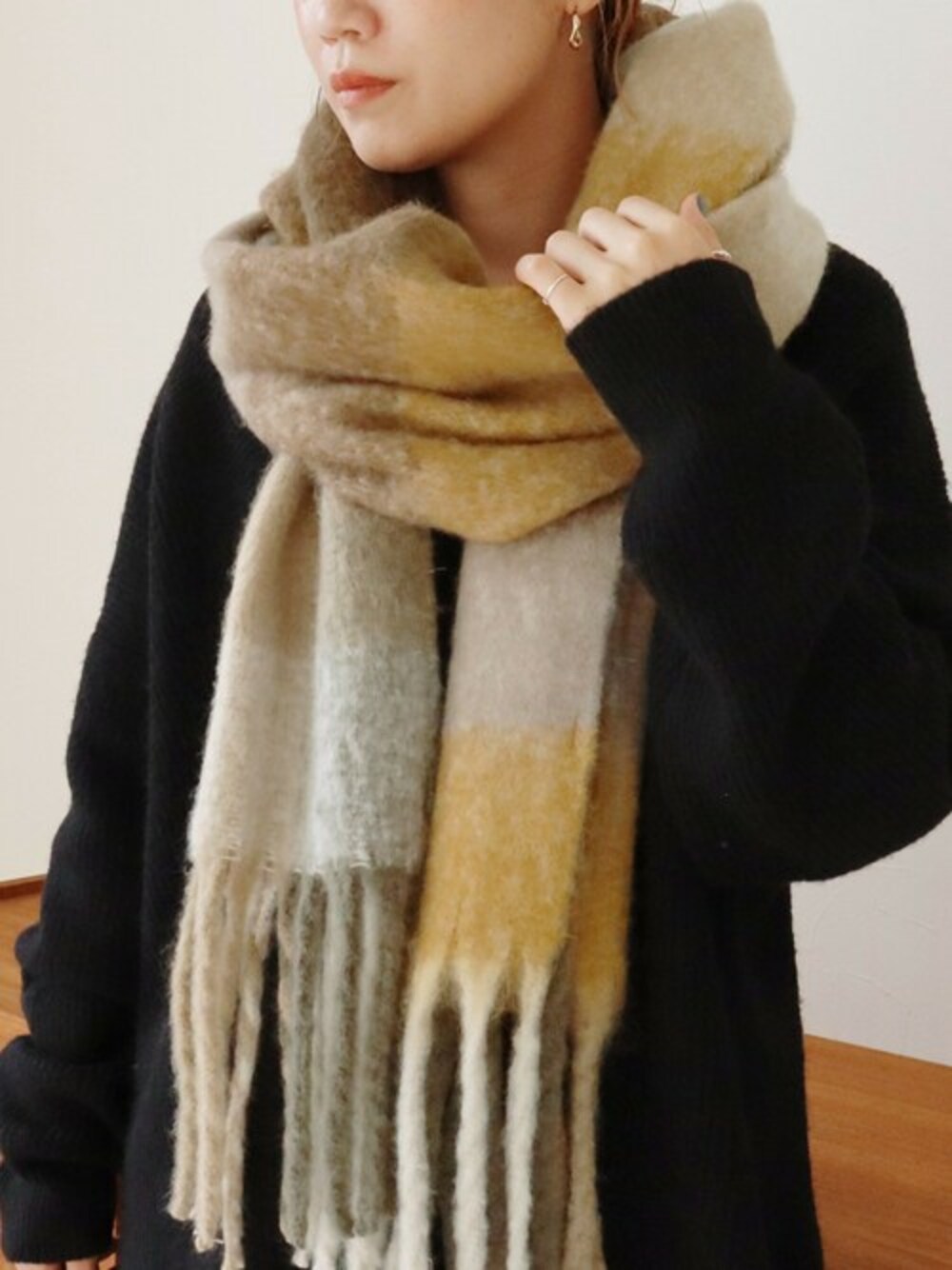 ブラウン系のストール/ショールを着用したレディースの秋コーディネートの1枚目の写真