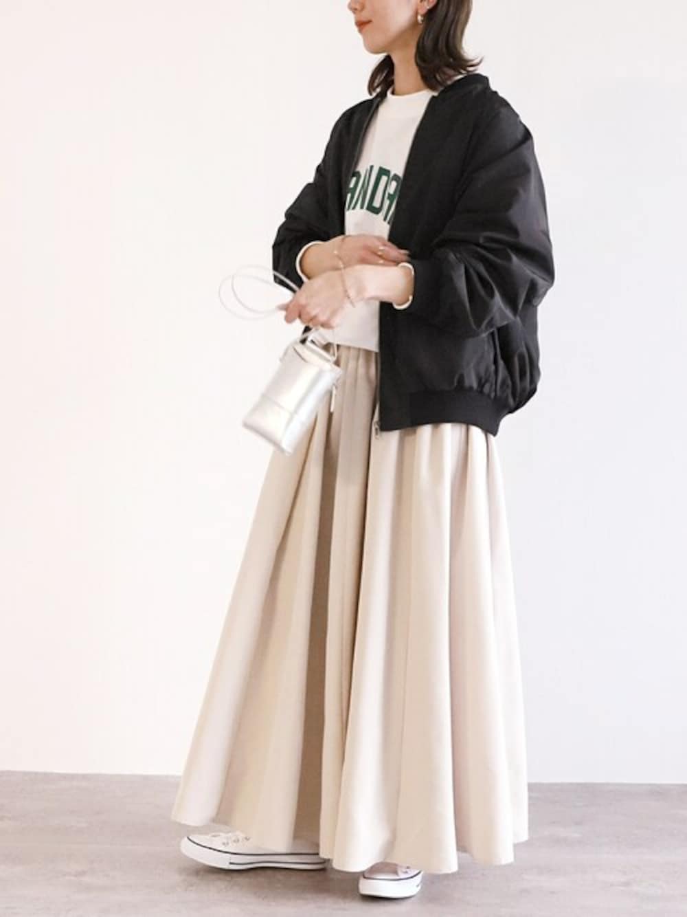 ブラック系のMA-1、ホワイト系のスカートを着用したレディースの冬コーディネートの1枚目の写真