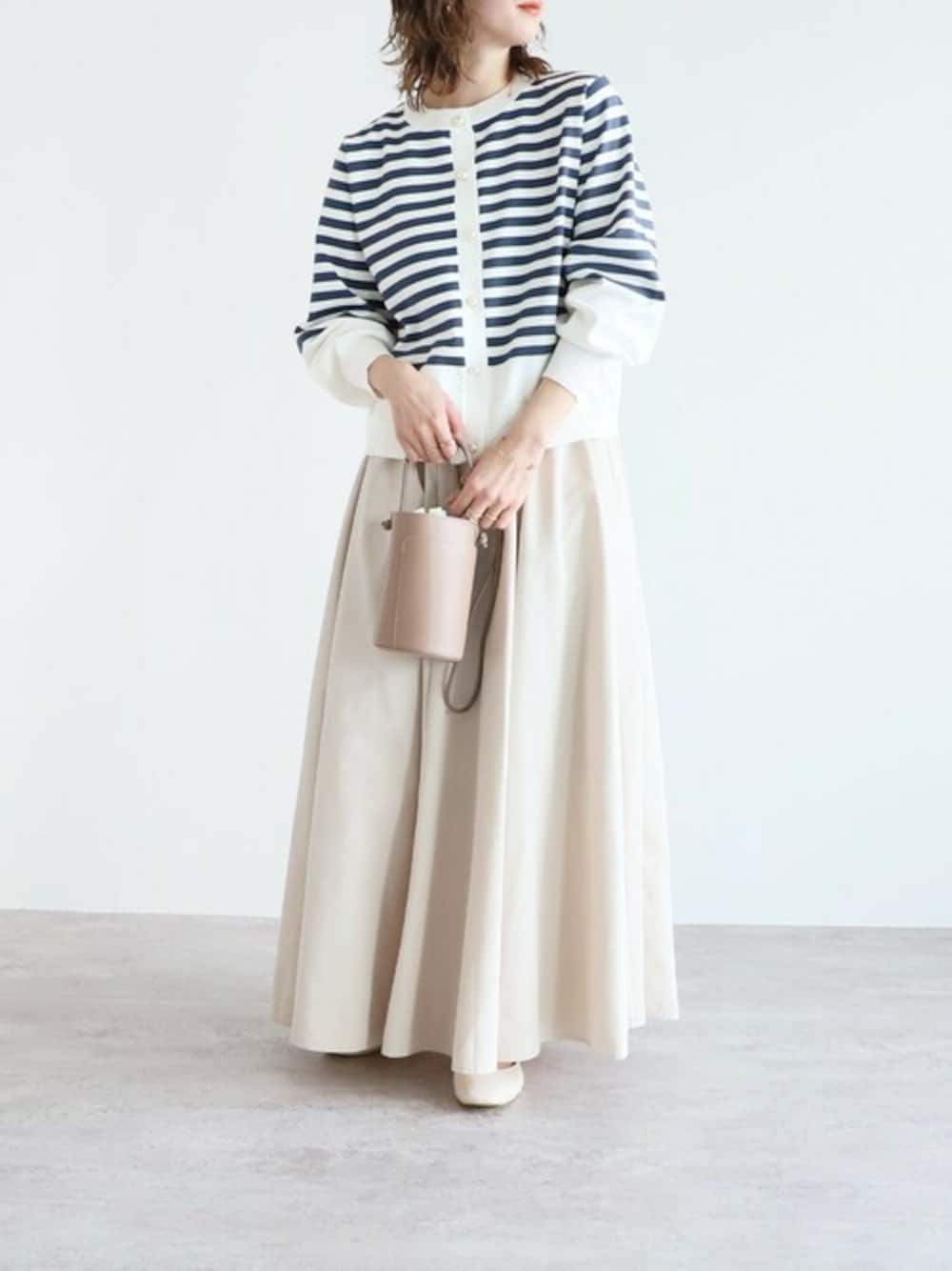 ブルー系のカーディガン/ボレロ、ホワイト系のスカートを着用したレディースの冬コーディネートの1枚目の写真