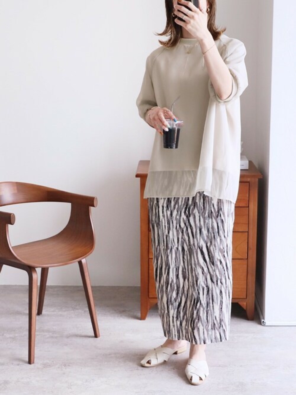 ベージュ系のTシャツ/カットソー、グレー系のスカートを着用したレディースの春コーディネートの1枚目の写真
