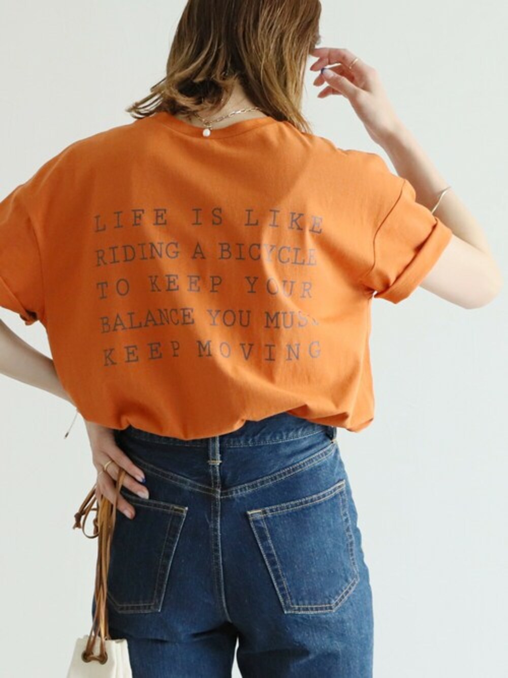 オレンジ系のTシャツ/カットソーを着用したレディースの夏コーディネートの1枚目の写真