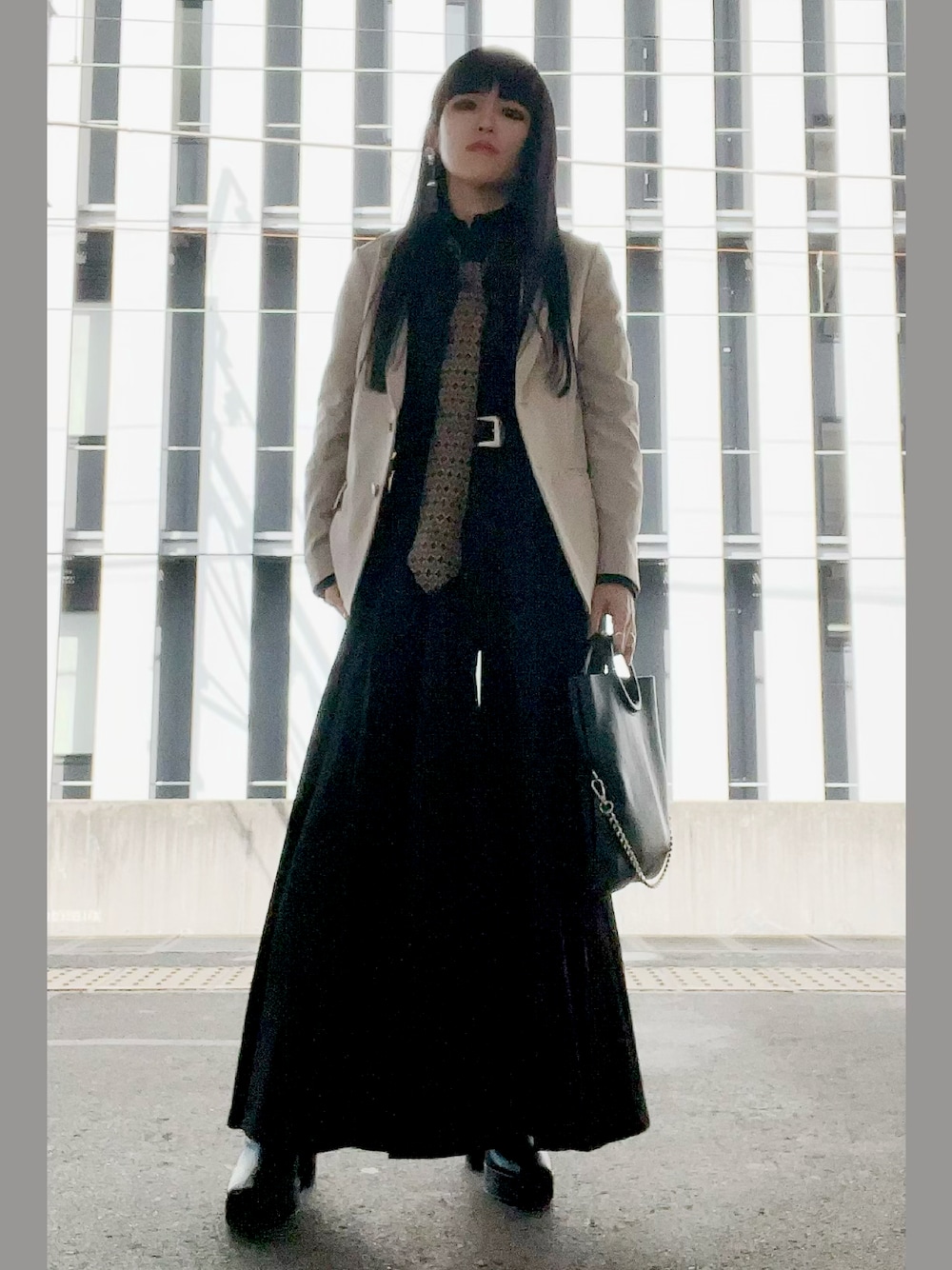 ブラック系のショルダーバッグ、ブラック系のその他パンツ、ベージュ系のジャケット/アウターを着用したレディースの春コーディネートの1枚目の写真