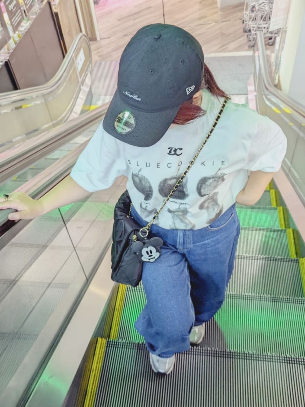 ブルー系のデニムパンツ、ブラック系のショルダーバッグ、シルバー系のスニーカーを着用したレディースの夏コーディネートの1枚目の写真