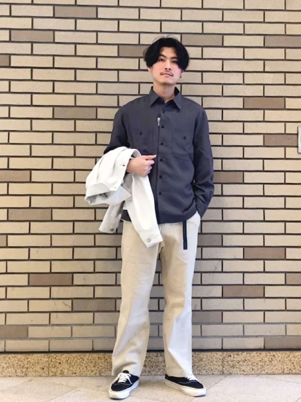 ブラック系のスニーカー、ベージュ系のデニムジャケット、グレー系のシャツ/ブラウスを着用したメンズの春コーディネートの1枚目の写真