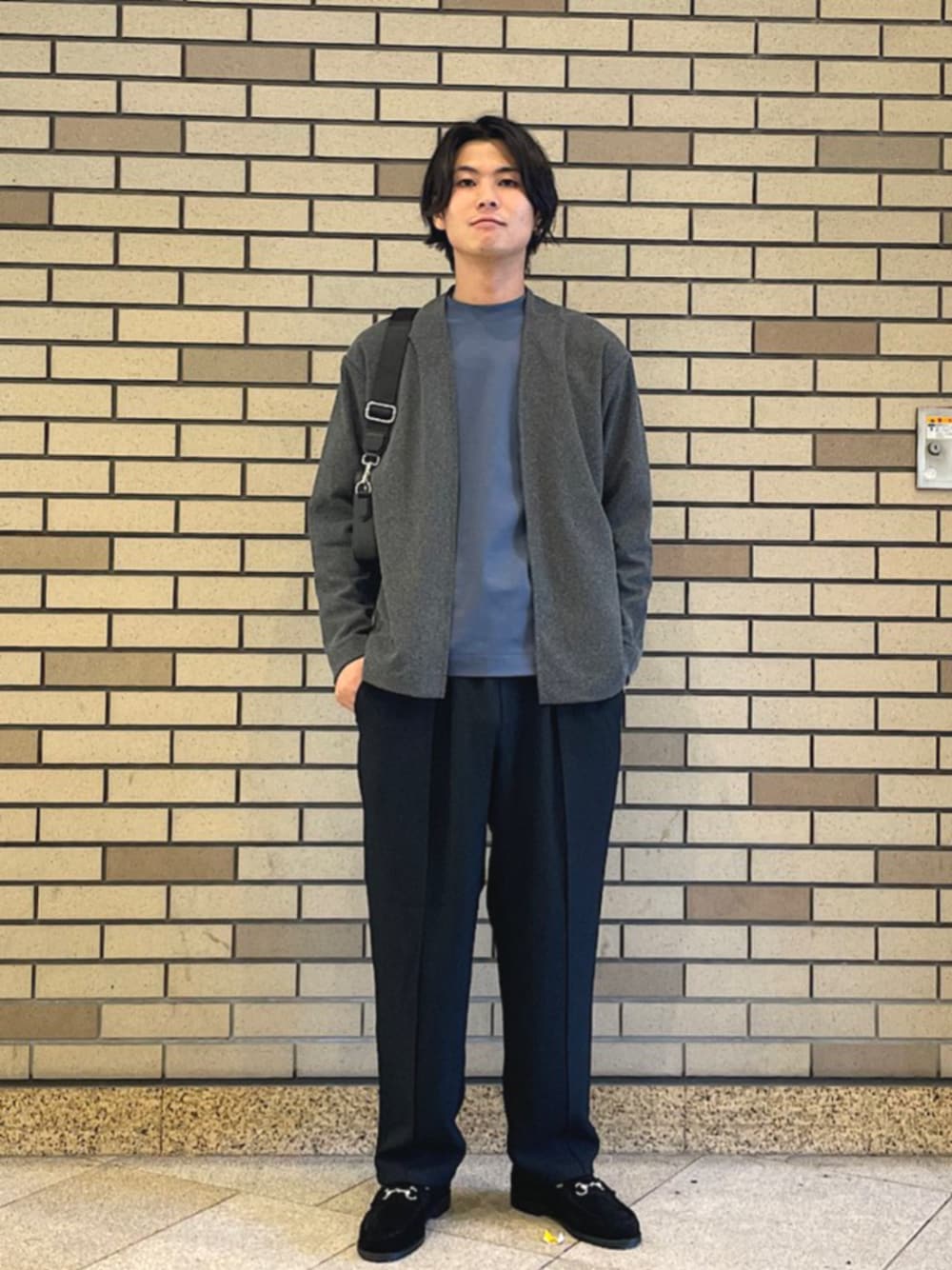 グレー系のカーディガン/ボレロ、ブルー系のTシャツ/カットソー、ブラック系のスラックスを着用したメンズの秋コーディネートの1枚目の写真