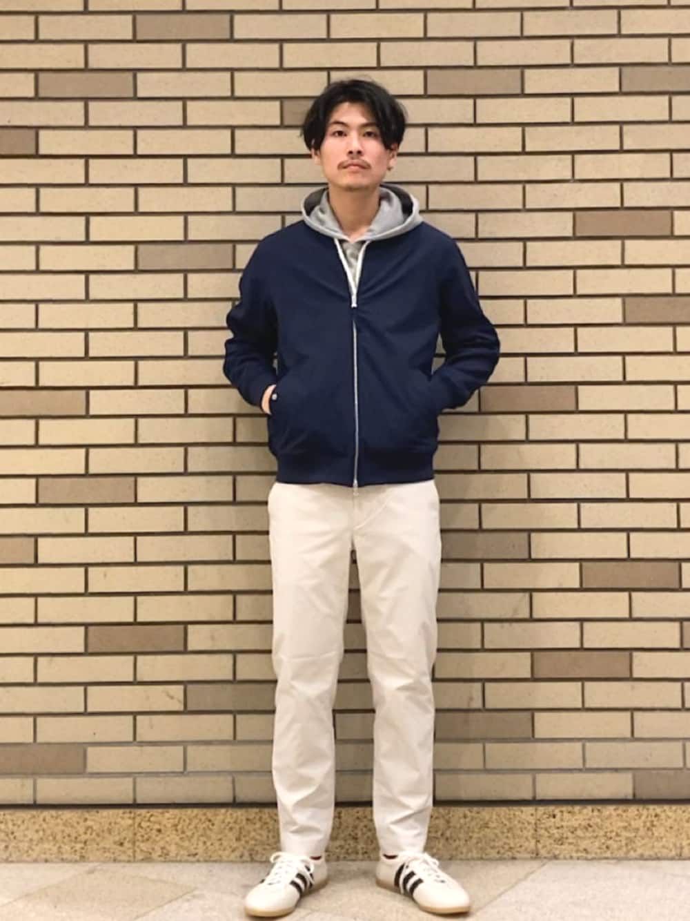 ブルー系のブルゾン、グレー系のパーカー、ベージュ系のその他パンツを着用したメンズの春コーディネートの1枚目の写真