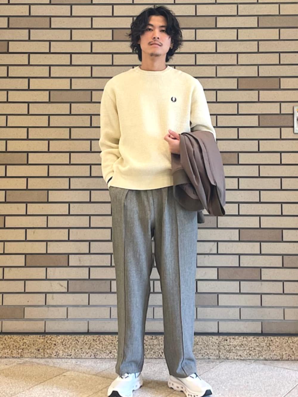 イエロー系のブルゾン、グレー系のスラックス、ベージュ系のスウェットを着用したメンズの秋コーディネートの1枚目の写真