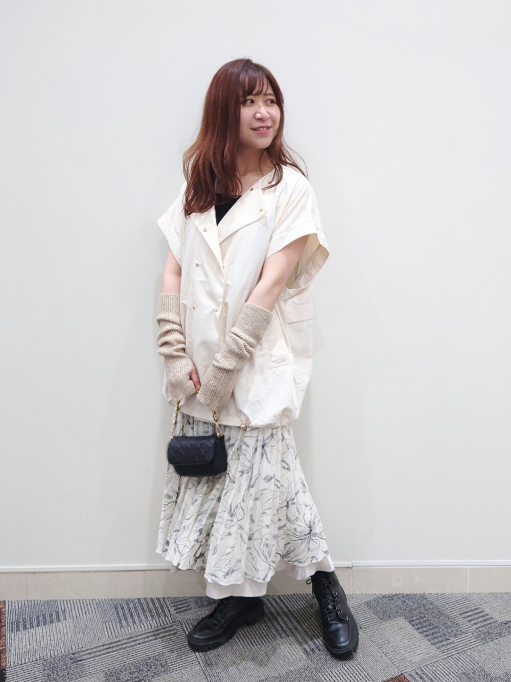 ブラック系のタンクトップ、ホワイト系のブルゾン、ブラック系のショルダーバッグを着用したレディースの秋コーディネートの1枚目の写真