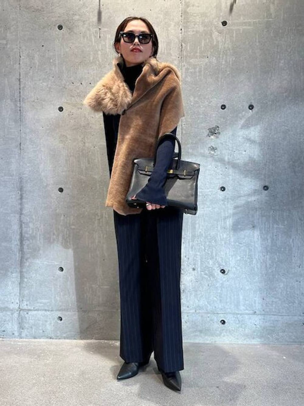 ブルー系のニット/セーター、ブルー系のスラックス、ブラック系のベルトを着用したレディースの秋コーディネートの1枚目の写真